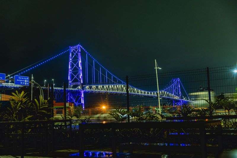 Durante a noite, a Ponte Hercílio Luz foi iluminada em roxo, marcando a força, a relevância e a consolidação da quinta edição do Mídia Market Roadshow.